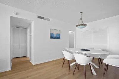 a white dining room with a white table and chairs at Condo w/2 Queen beds & Ocean View | Tides in Hollywood