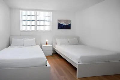 two beds in a room with white walls and a window at Condo w/2 Queen beds & Ocean View | Tides in Hollywood