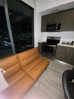 a living room with a brown couch in a kitchen at Comfortable apartment in Downtown Miami in Miami