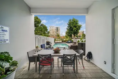 a patio with a table and chairs and a pool at Modern Haven in Paradise w Heated Eco Pool 5B 4B in Miami