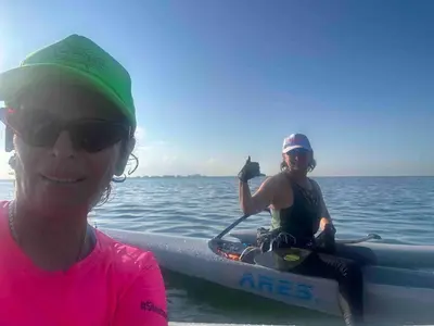 two women sitting on a paddle board in the water at Modern Haven in Paradise w Heated Eco Pool 5B 4B in Miami