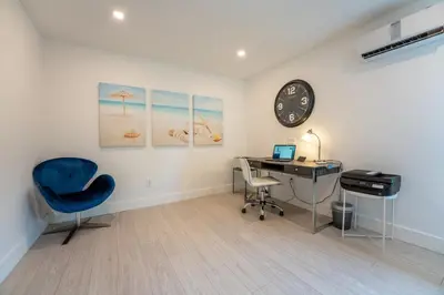 an office with a desk and a clock on a wall at TROPICAL Villa with POOL in Private Island in Miami Beach