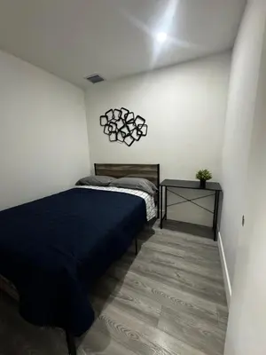 a bedroom with a bed and a side table at Santuaria Hollywood in Hollywood