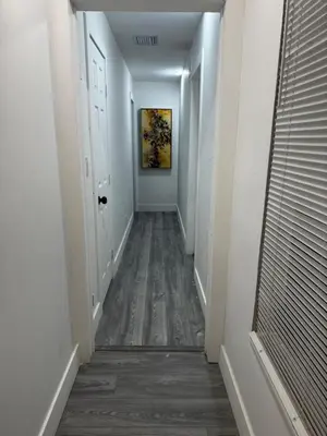 a hallway with white walls and a wooden floor at Santuaria Hollywood in Hollywood
