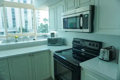 a kitchen with a microwave and a stove top oven at Shine Suites Duplex Bay7A in Miami Beach
