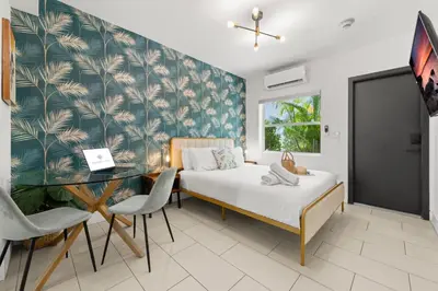a bedroom with a bed and a glass table at Byron Avenue Suites in Miami Beach
