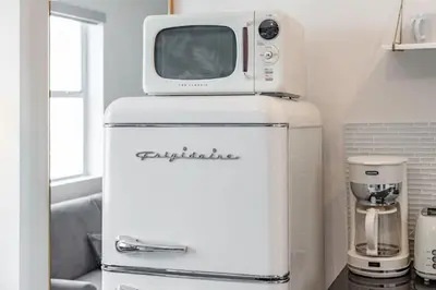 a microwave sitting on top of a refrigerator at Byron Avenue Suites in Miami Beach