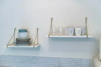 a kitchen with two shelves with plates and bowls at Byron Avenue Suites in Miami Beach