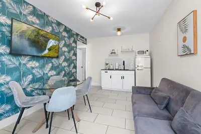 a living room with a couch and a table and chairs at Byron Avenue Suites in Miami Beach