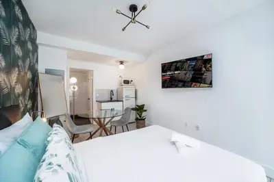 a bedroom with a bed and a dining room at Byron Avenue Suites in Miami Beach