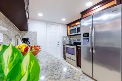 a kitchen with a stainless steel refrigerator and a bowl of fruit at Walk to Coral Gables| Beautiful Property| Sleeps 8 in Miami