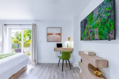 a bedroom with a bed and a desk with a laptop at Walk to Coral Gables| Beautiful Property| Sleeps 8 in Miami