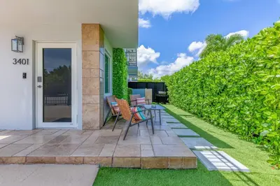 a patio with chairs and a table on a lawn at Walk to Coral Gables| Beautiful Property| Sleeps 8 in Miami