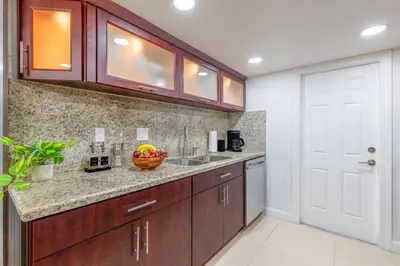 a kitchen with wooden cabinets and a bowl of fruit on the counter at Walk to Coral Gables| Beautiful Property| Sleeps 8 in Miami