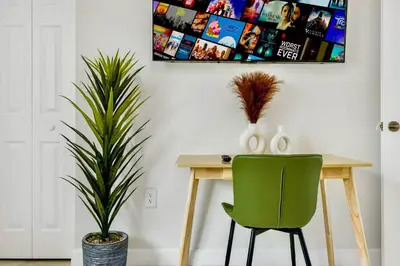 a dining room with a table and a green chair at Prime Miami Retreat | Sleeps 12 | Parking, BBQ! in Miami