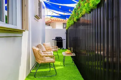 a patio with two chairs and a table with green grass at Prime Miami Retreat | Sleeps 12 | Parking, BBQ! in Miami