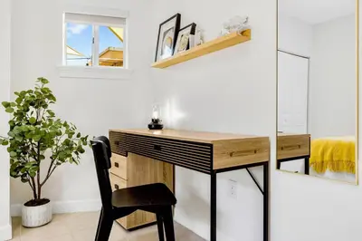 a desk in a room with a chair and a plant at Prime Miami Retreat | Sleeps 12 | Parking, BBQ! in Miami