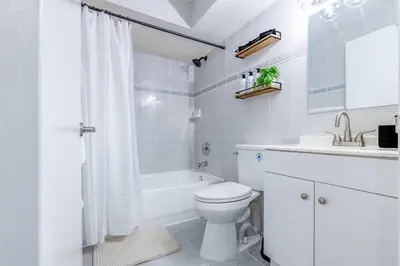 a white bathroom with a toilet and a tub and a sink at Beachy Living |Sleep 8 Best Location | BBQ & Patio in Miami