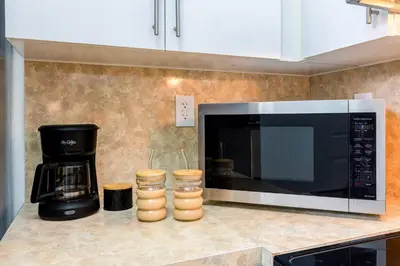 a kitchen counter with a microwave and a coffee maker at Beachy Living |Sleep 8 Best Location | BBQ & Patio in Miami