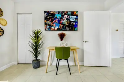 a dining room with a table and a green chair at Tropical | 8PPL | Top Location | Parking | Laundry in Miami