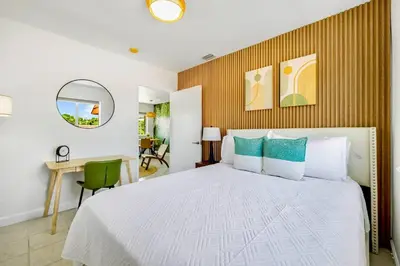 a bedroom with a white bed and a desk and a chair at Tropical | 8PPL | Top Location | Parking | Laundry in Miami