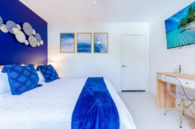 a bedroom with a bed with blue pillows and a desk at Marina | Top Location | 8PPL | Parking | Laundry in Miami