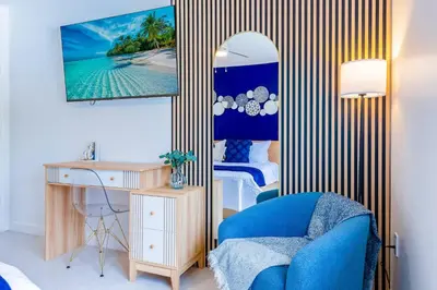 a bedroom with a blue chair and a desk and a mirror at Marina | Top Location | 8PPL | Parking | Laundry in Miami