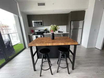 a kitchen with a wooden table and two bar stools at Downtown Miami Luxury Condo apartment in Miami
