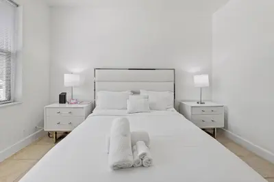 a white bedroom with a large white bed and two night stands at Stay in Brickell near Kaseya Center & South Beach in Miami