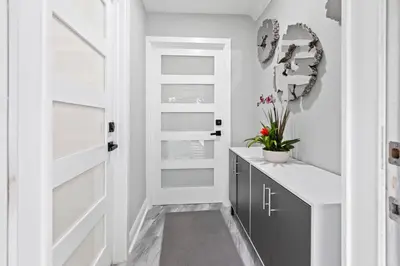 a bathroom with white walls and a black door at Charming Hideaway Near Beach, Nightlife & Shops in Fort Lauderdale