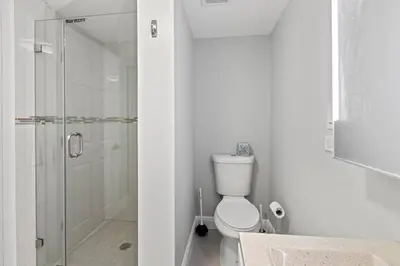 a white bathroom with a shower and a toilet at Charming Hideaway Near Beach, Nightlife & Shops in Fort Lauderdale