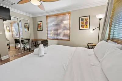 a bedroom with a white bed and a table at Prime Location – Walkable to Wilton Drive in Fort Lauderdale