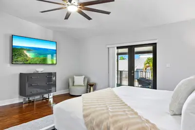 a white bedroom with a bed and a tv at Cherry RoyaleGrand Villa in Davie