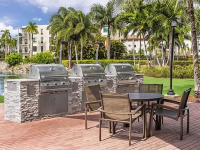 a patio with a grill and a table and chairs at Marriott's Villas at Doral 2BR Apartment with Resort Access in Miami