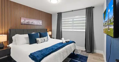 a bedroom with a large bed with blue pillows at Chicago Vibe Heated Pool 5BR 2BTH in Miami