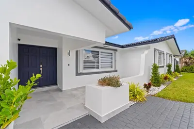 a white house with a blue door at Chicago Vibe Heated Pool 5BR 2BTH in Miami