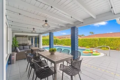 a patio with a table and chairs and a pool at Chicago Vibe Heated Pool 5BR 2BTH in Miami