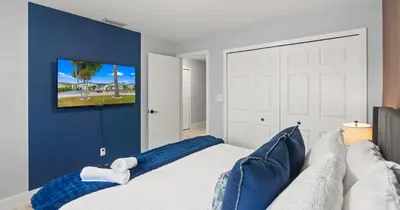 a bedroom with a white bed with blue walls at Chicago Vibe Heated Pool 5BR 2BTH in Miami