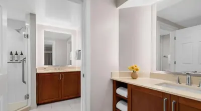 a white bathroom with a sink and a shower at Marriott's BeachPlace Towers 2BR Apartment with Resort Access in Fort Lauderdale