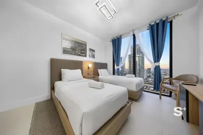 a hotel room with two beds and a desk at Chic 2-Bedroom Downtown Condo with Breathtaking City & Waterfront Views in Miami