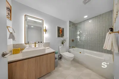 a bathroom with a sink and a tub and a toilet at Sleek 3-BD Downtown Miami Condo with Water & City Views in Miami
