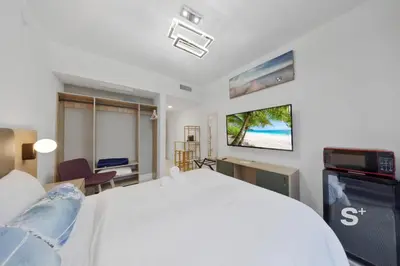 a bedroom with a white bed and a tv at Sleek 3-BD Downtown Miami Condo with Water & City Views in Miami