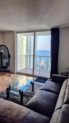 a living room with a couch and a glass table at 36th Floor Brickell Suite with City Skyline and Bay Views in Miami