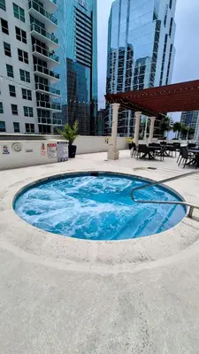 a large blue pool in the middle of a city at 36th Floor Brickell Suite with City Skyline and Bay Views in Miami
