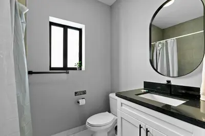 a white bathroom with a sink and a mirror at Urban Comfort - 20min to Beach & Airport in Miami