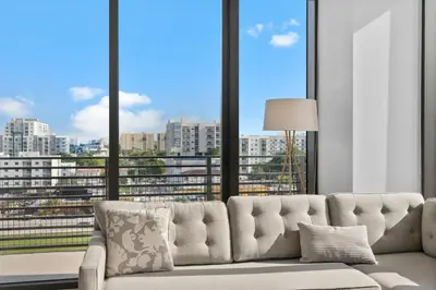 a living room with a couch and a large window at Luxury Pent House with Downtown Views in Miami