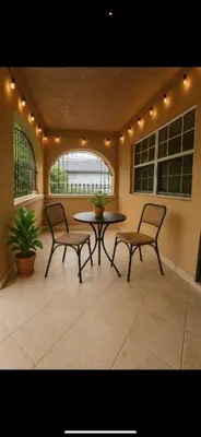 a patio with two chairs and a table and a table at Casa Rosa Wynwood in Miami