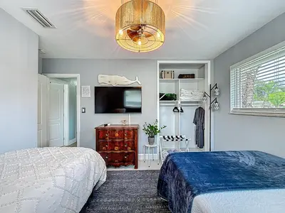 a bedroom with a bed and a flat screen tv at Boho Oasis -World Cup base- under 20 min to stadium & FLL airport in Fort Lauderdale