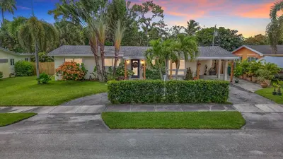 a house with palm trees and a driveway at Boho Oasis -World Cup base- under 20 min to stadium & FLL airport in Fort Lauderdale