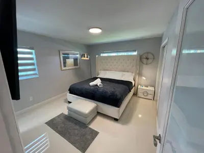 a bedroom with a bed and a walk in shower at Spacious 4BR Home 5 Min from Hard Rock Stadium in Miami Gardens